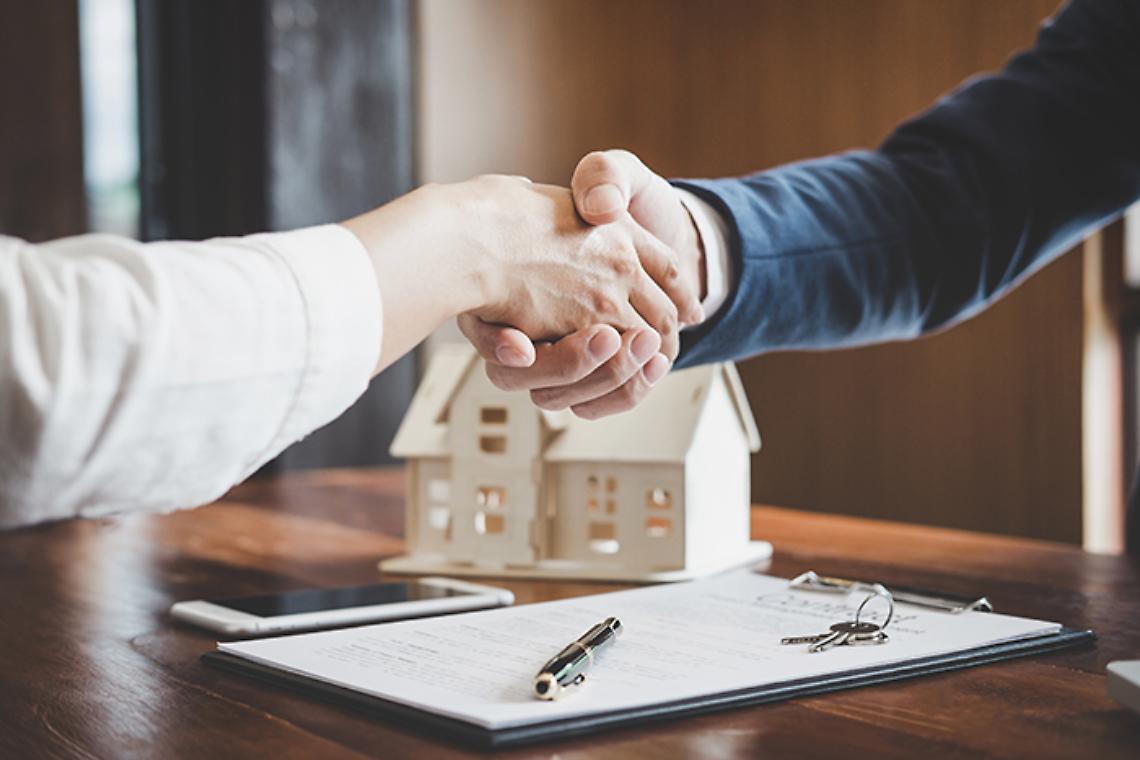 Estate agent and customer shaking hands after finished contract