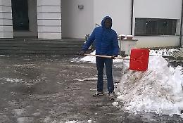 Il sagrato &egrave; pieno di neve: lo pulisce un profugo
