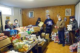Panettoni e giocattoli nelle borse alimentari per le famiglie in difficolt&agrave;
