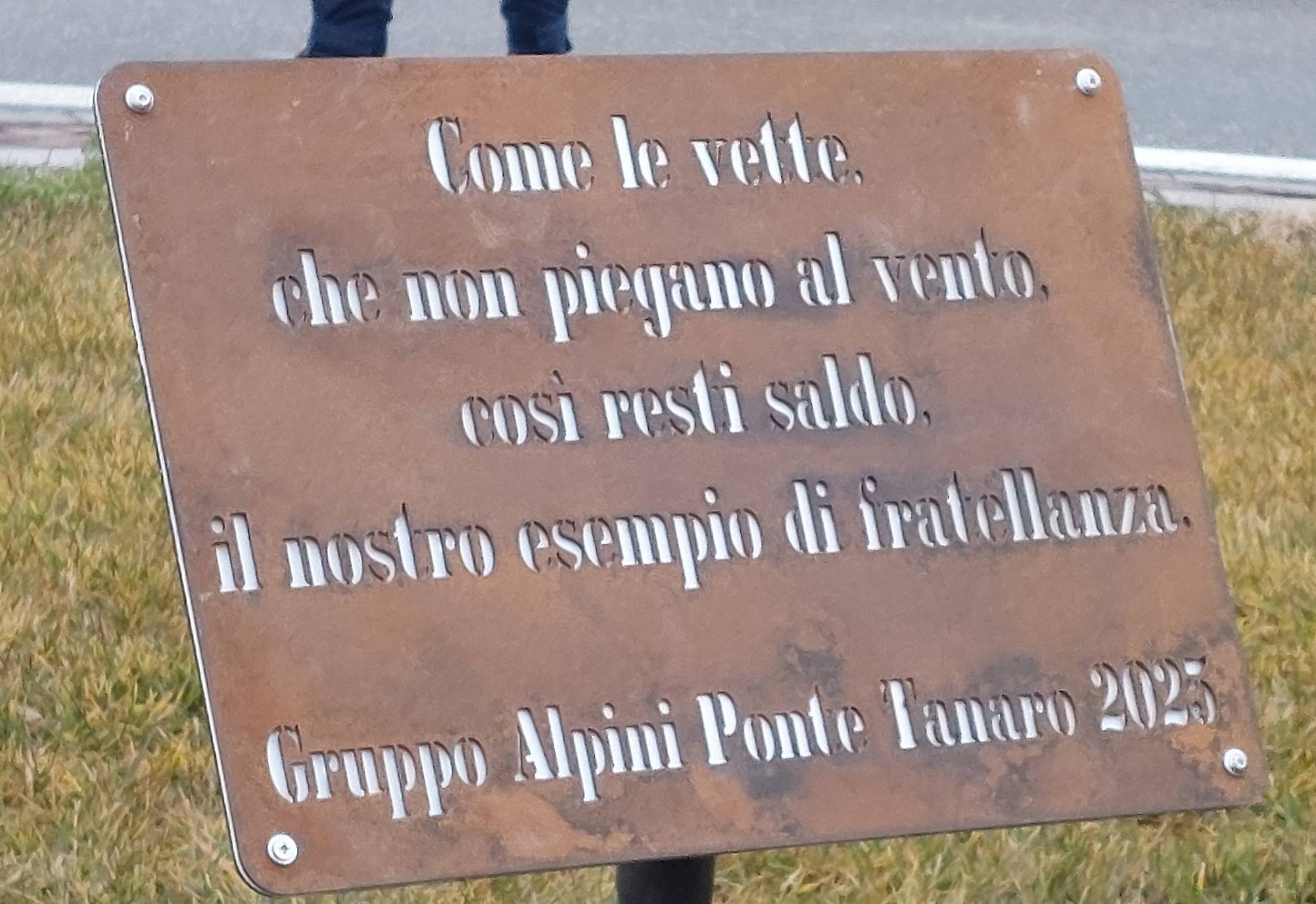 La scritta a lato della scultura sulla rotonda di via Cuneo