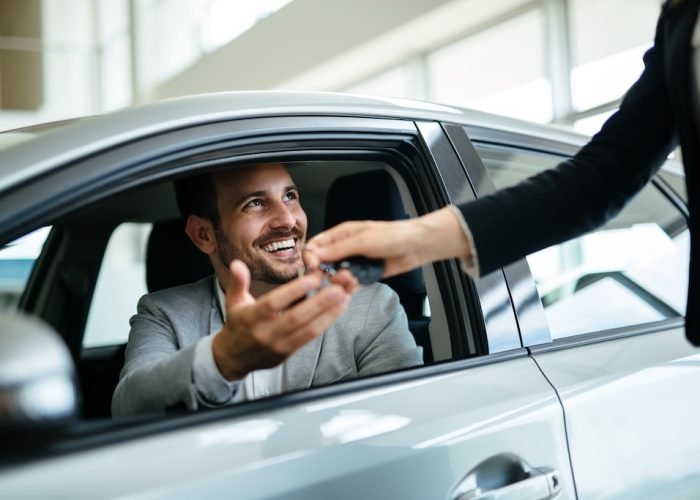 Portrait of happy customer buying new car