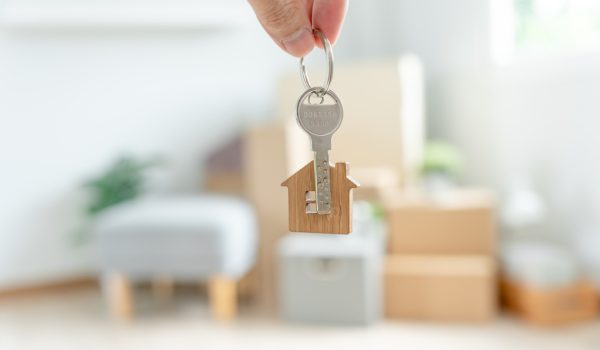 Moving house, relocation. Woman hold key house keychain in new apartment. move in new home. Buy or rent real estate. flat tenancy, leasehold property, new landlord, dwelling, loan, mortgage.