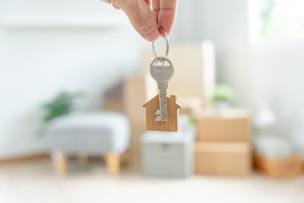 Moving house, relocation. Woman hold key house keychain in new apartment. move in new home. Buy or rent real estate. flat tenancy, leasehold property, new landlord, dwelling, loan, mortgage.