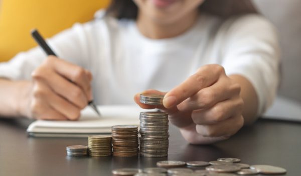 Financial, asian young woman, girl putting stack coins on table for calculate cost sitting in living room at home, financial plans to spend enough money on his income for saving money and payment