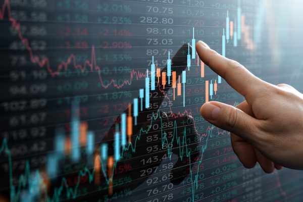 Candlestick chart and data of financial market.  Analyst pointing the chart.