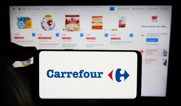 Stuttgart, Germany : Person holding cellphone with logo of French retail company Carrefour SA in front of business webpage Focus on phone display