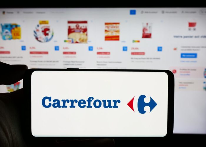 Stuttgart, Germany : Person holding cellphone with logo of French retail company Carrefour SA in front of business webpage Focus on phone display