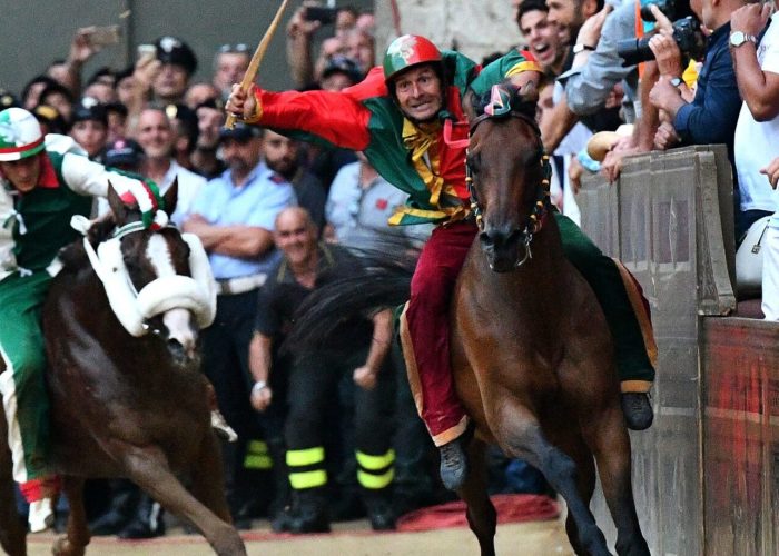 Jockey of the contrada "Drago" Andrea Mari (R) competes with his horse Rocco Nice and wins 
the historical Italian horse race Palio di Siena on July 2, 2018, in Siena. / AFP PHOTO / Vincenzo PINTO