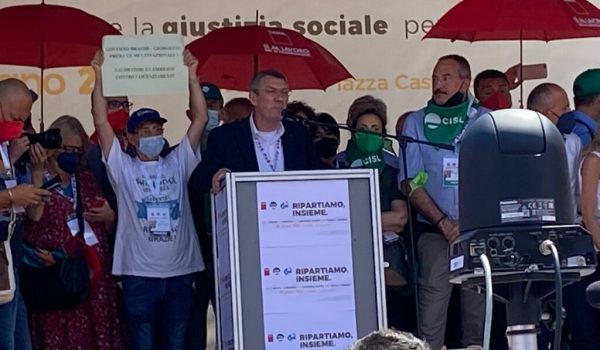 Un lavoratore Embraco a fianco di Maurizio Landini