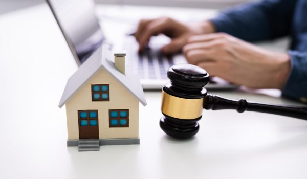 House Model With Gavel In Front Of A Businessperson Using Laptop On Wooden Desk.House,Model,With,Gavel,In,Front,Of,Businessperson,Using,Laptop,estate, real, lawyer, foreclosure, home, bankruptcy, government, litigation,estate, real, lawyer, foreclosure, home, bankruptcy, government, litigation, gavel, property, laptop, auction, model, courtroom, court, legal, law, arbitration, man, justice, house, hand, sale, order, housing, finance, men, desk, crime, electronic, technology, young, investment, mallet, wood, male, verdict, miniature, wooden, human, wireless, closeup, caucasian, close-up