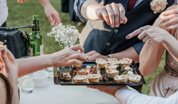 group of friends eating finger food at a wedding r utc
