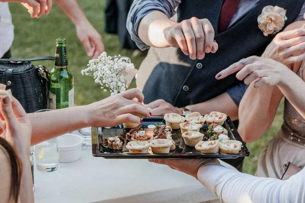 group of friends eating finger food at a wedding r utc