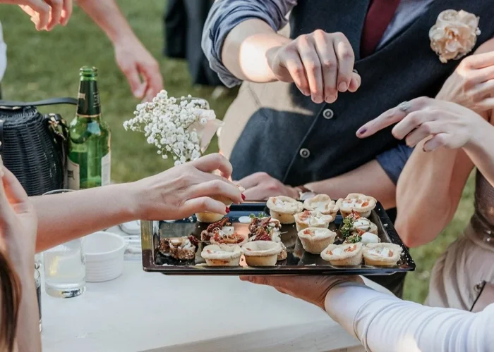 group of friends eating finger food at a wedding r utc