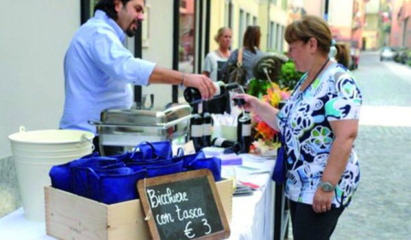 In centro con un piatto e un bicchiereE' la due giorni di Wine Street Tasting