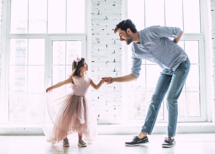 I love you, dad! Handsome young man is dancing at home with his little cute girl. Happy Father's Day!